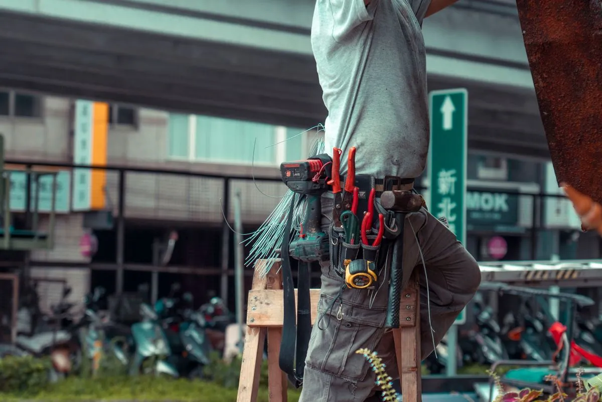 Artisan sur une échelle effectuant la maintenance préventive