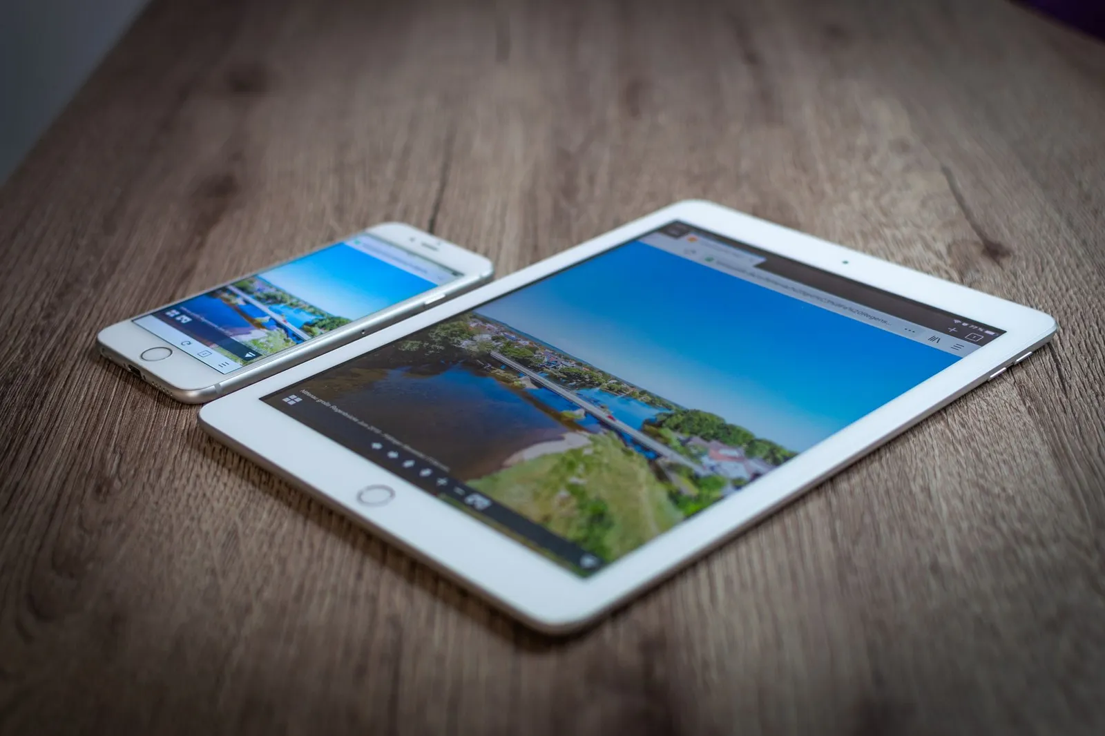 Tablet e smartphone su un tavolo di legno, pronti a mostrare una lettera di benvenuto
