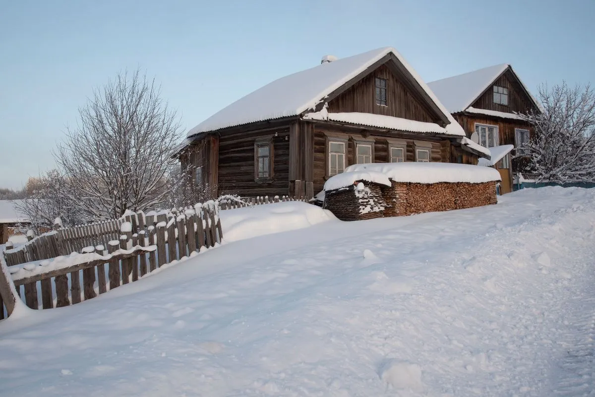 Wooden cabins surrounded by snow and frost in winter