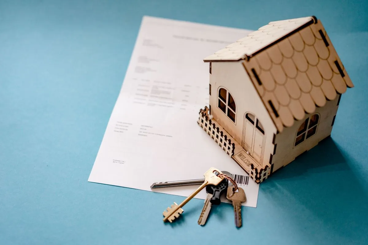 Wooden house model, keys and a printed form on a table, standing for the declaration of a holiday rental before it is listed