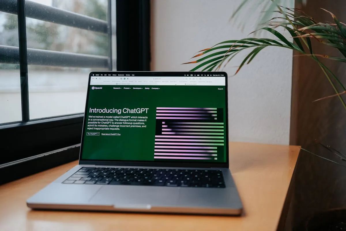 Ordinateur portable posé sur un bureau près d'une fenêtre, affichant la page de ChatGPT, pendant qu'un hôte étudie comment relier son assistant IA à ses réservations Airbnb