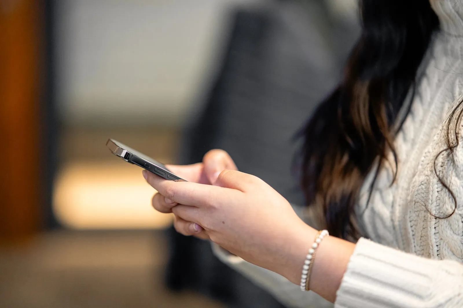 Plano aproximado de uma mulher a segurar o smartphone para ler mensagens