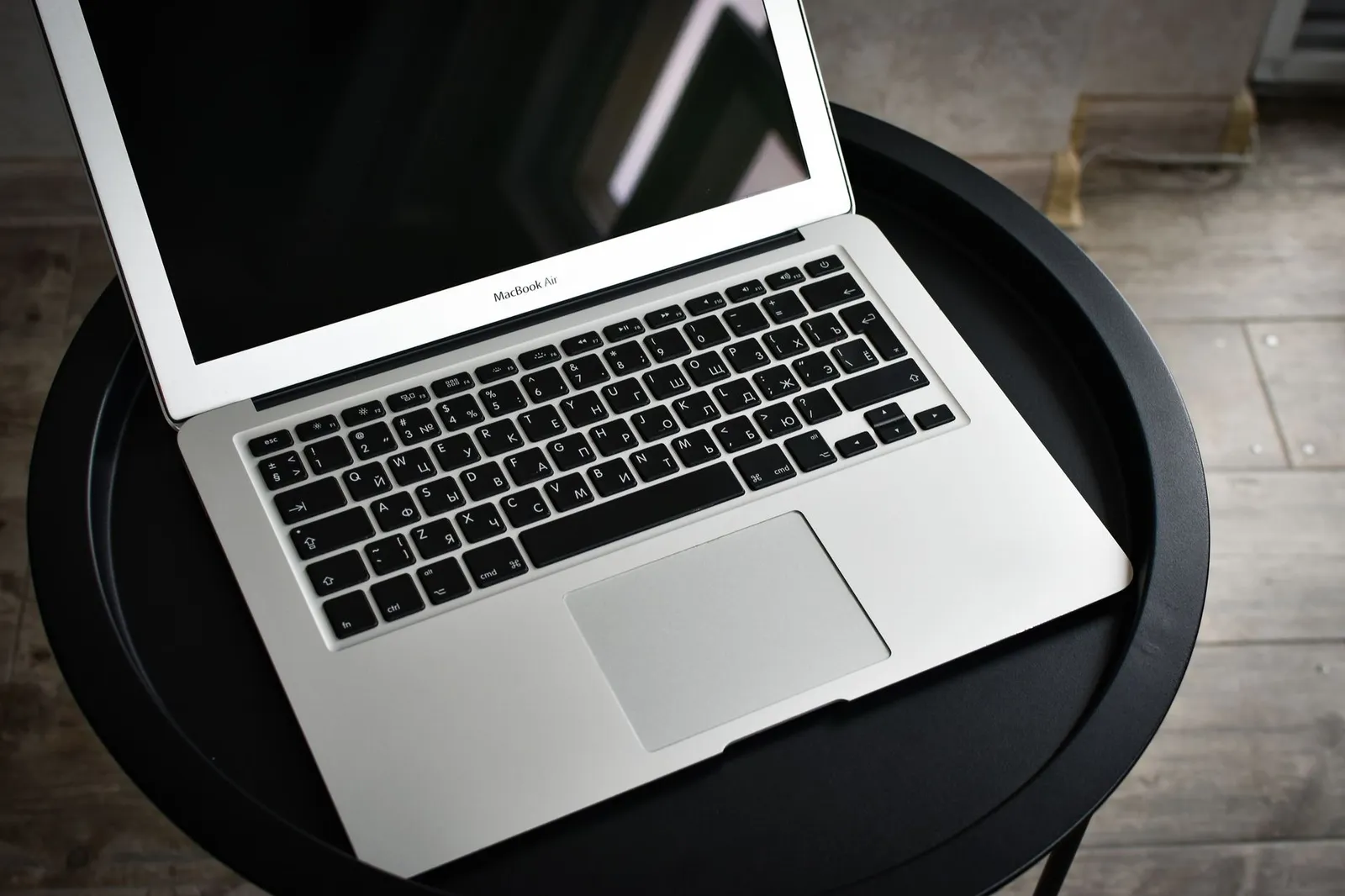 Aufgeklappter Laptop auf einem runden schwarzen Beistelltisch