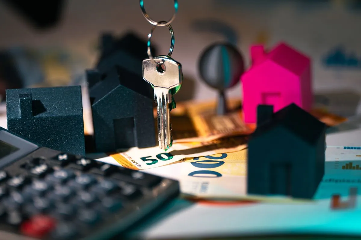 House keys, model houses, a calculator and euro banknotes, illustrating the tax cost of a furnished holiday let in France