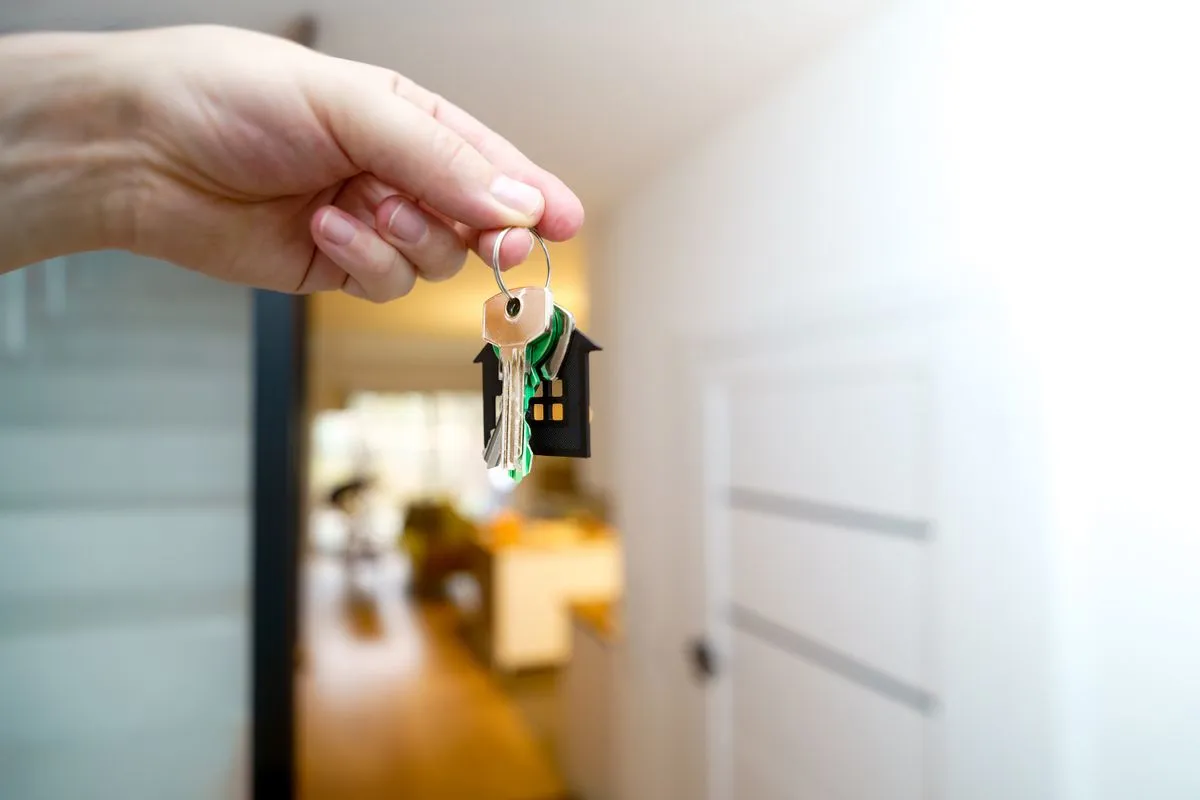 Host holding the keys of a rental apartment, ready to register the unit and display its registration number