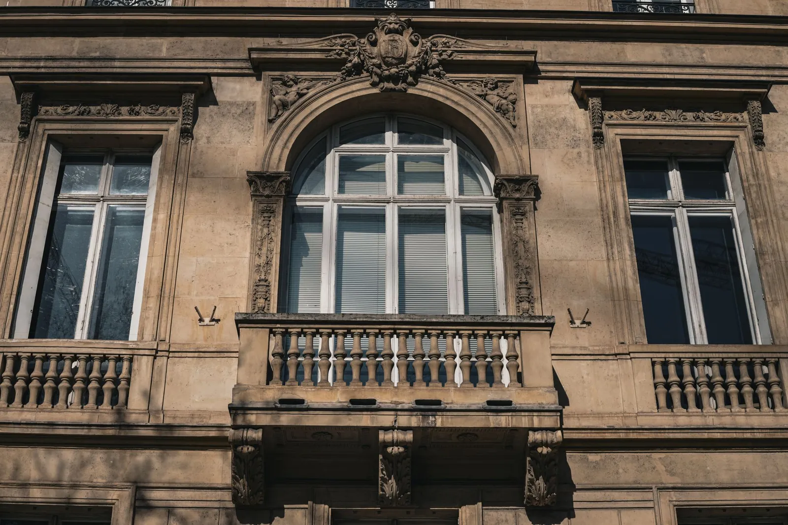 Facciata in pietra scolpita con un balcone su un palazzo di appartamenti parigino