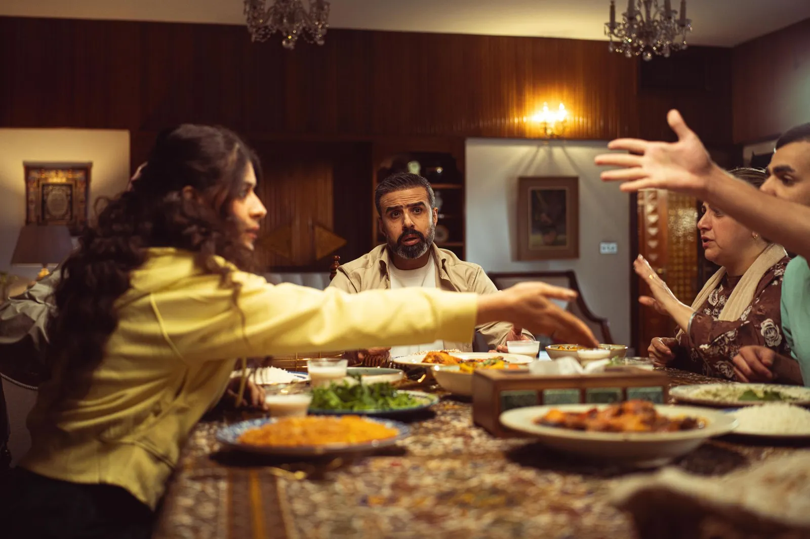 Große Gruppe beim lebhaften Abendessen an einem vollen Tisch