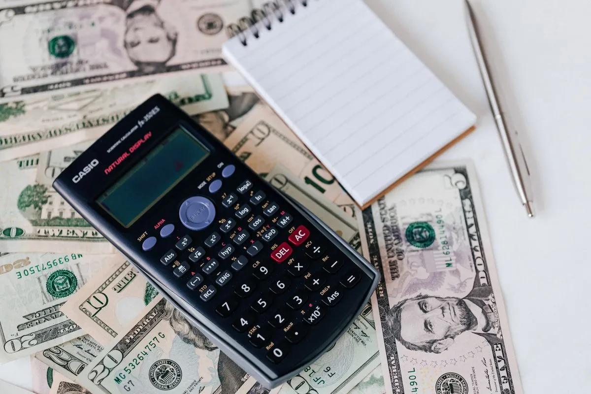 Calculator on top of banknotes, illustrating the maths of Airbnb's 15.5% host-only service fee