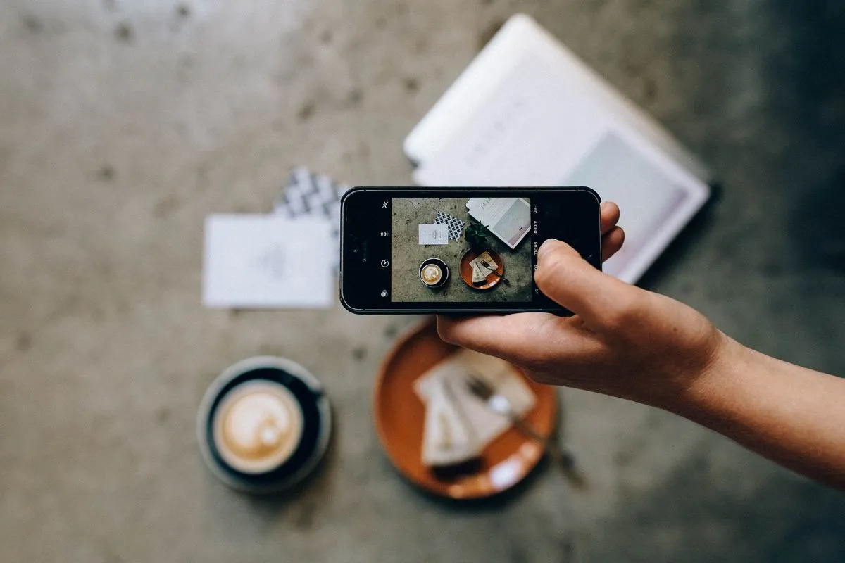 Hand capturing a photo with a smartphone for social media