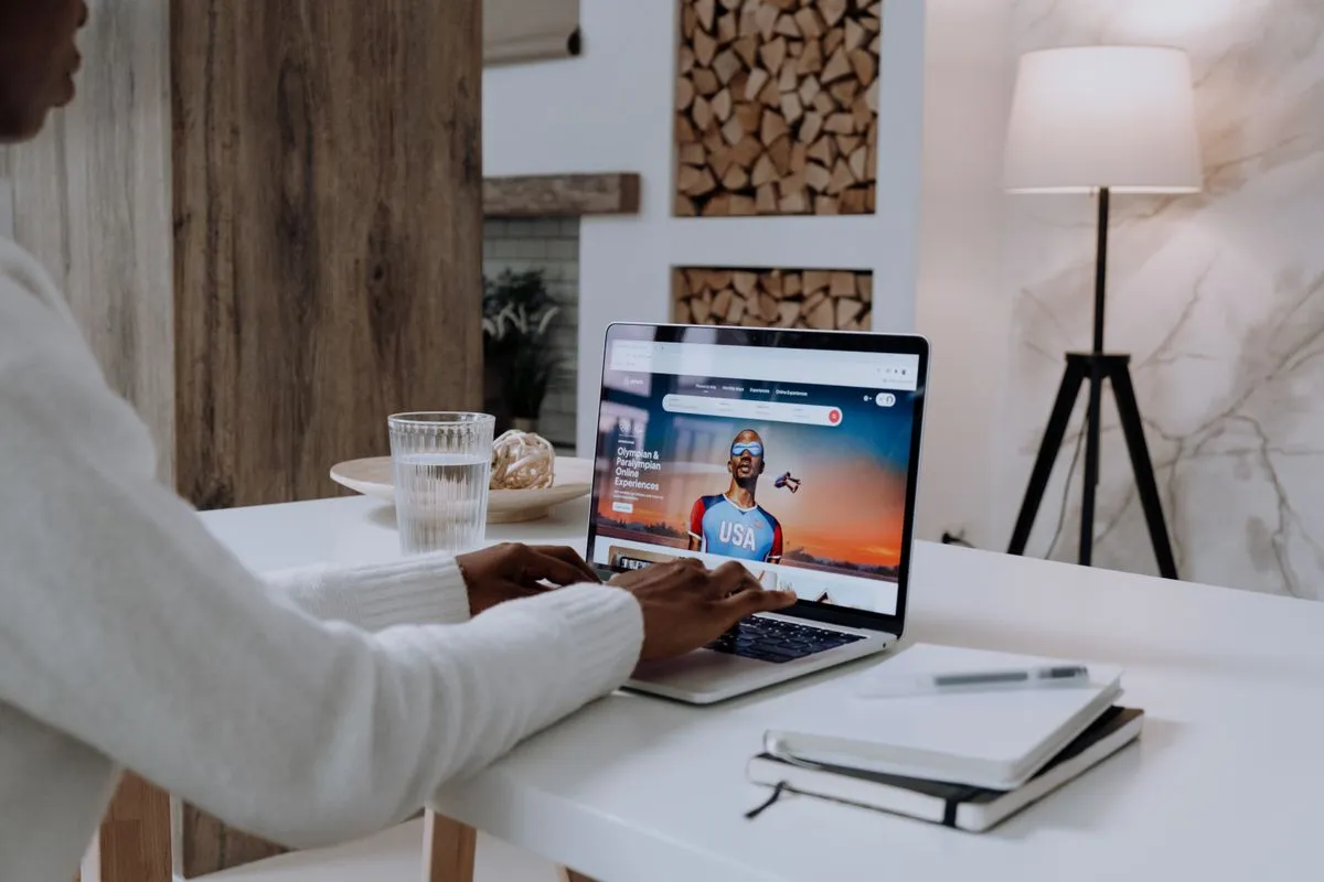Guest typing on a laptop open on the Airbnb homepage, the starting point of an AI-assisted search