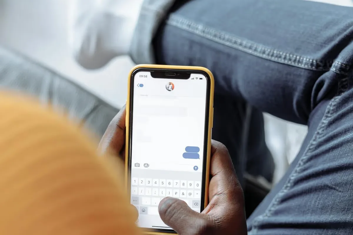 Person schreibt auf dem Smartphone mit WhatsApp zur Gästekommunikation
