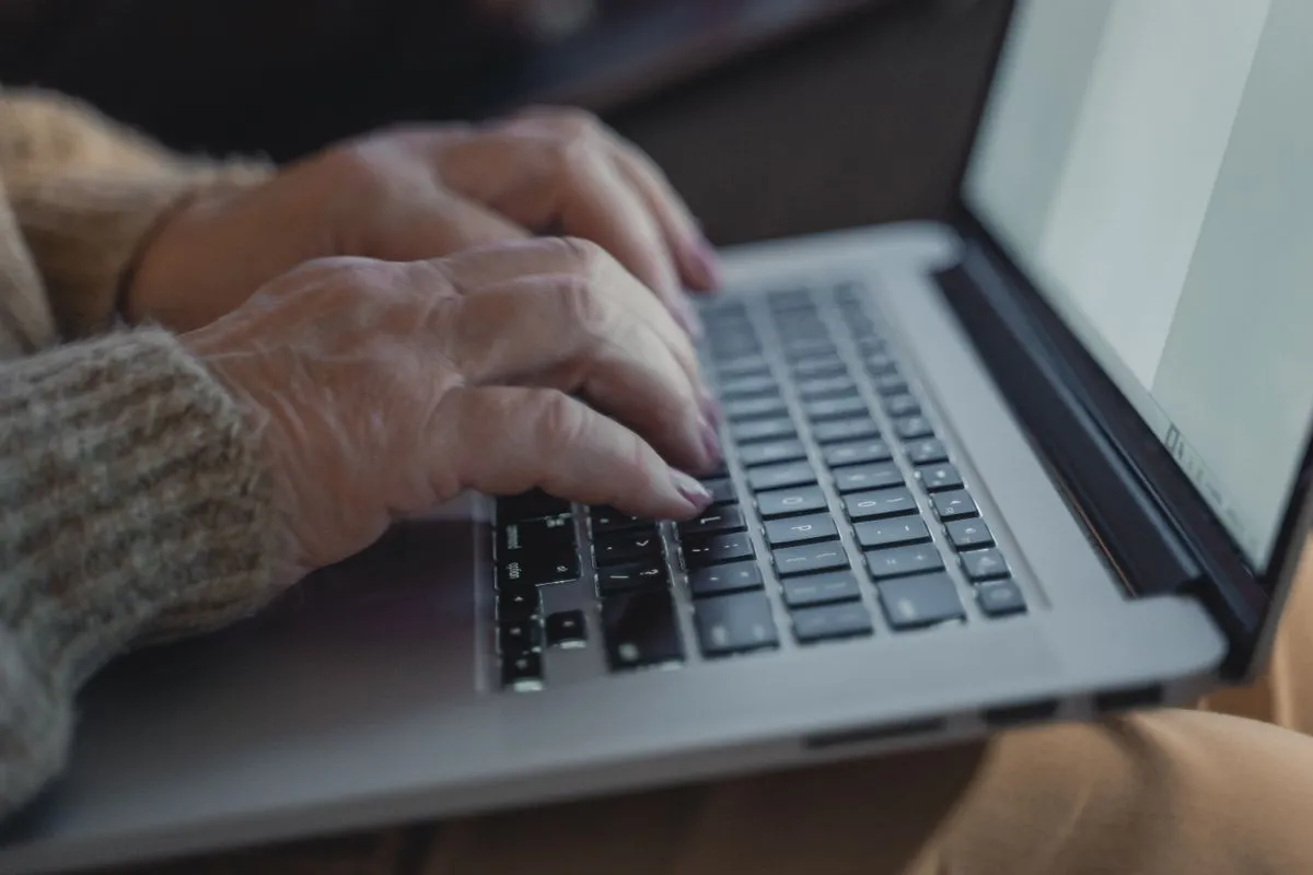 Owner typing on a laptop to sign in to Airbnb and approve a software connection for their concierge