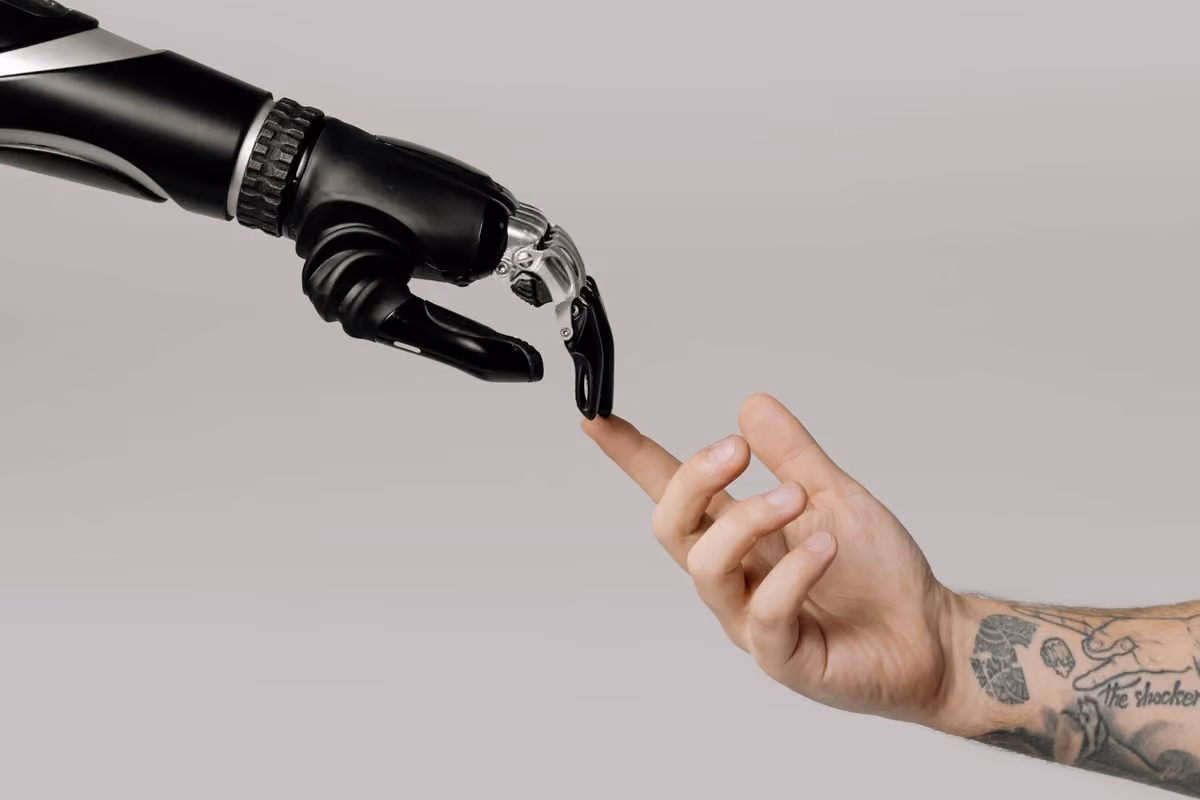 Robotic hand reaching toward a human hand, illustrating guests interacting with an AI assistant
