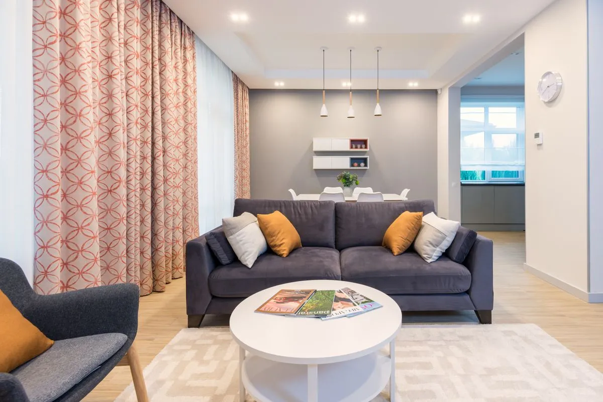 Soggiorno moderno e luminoso con divano e zona pranzo, il tipo di alloggio pubblicato sia su Airbnb sia su Booking.com