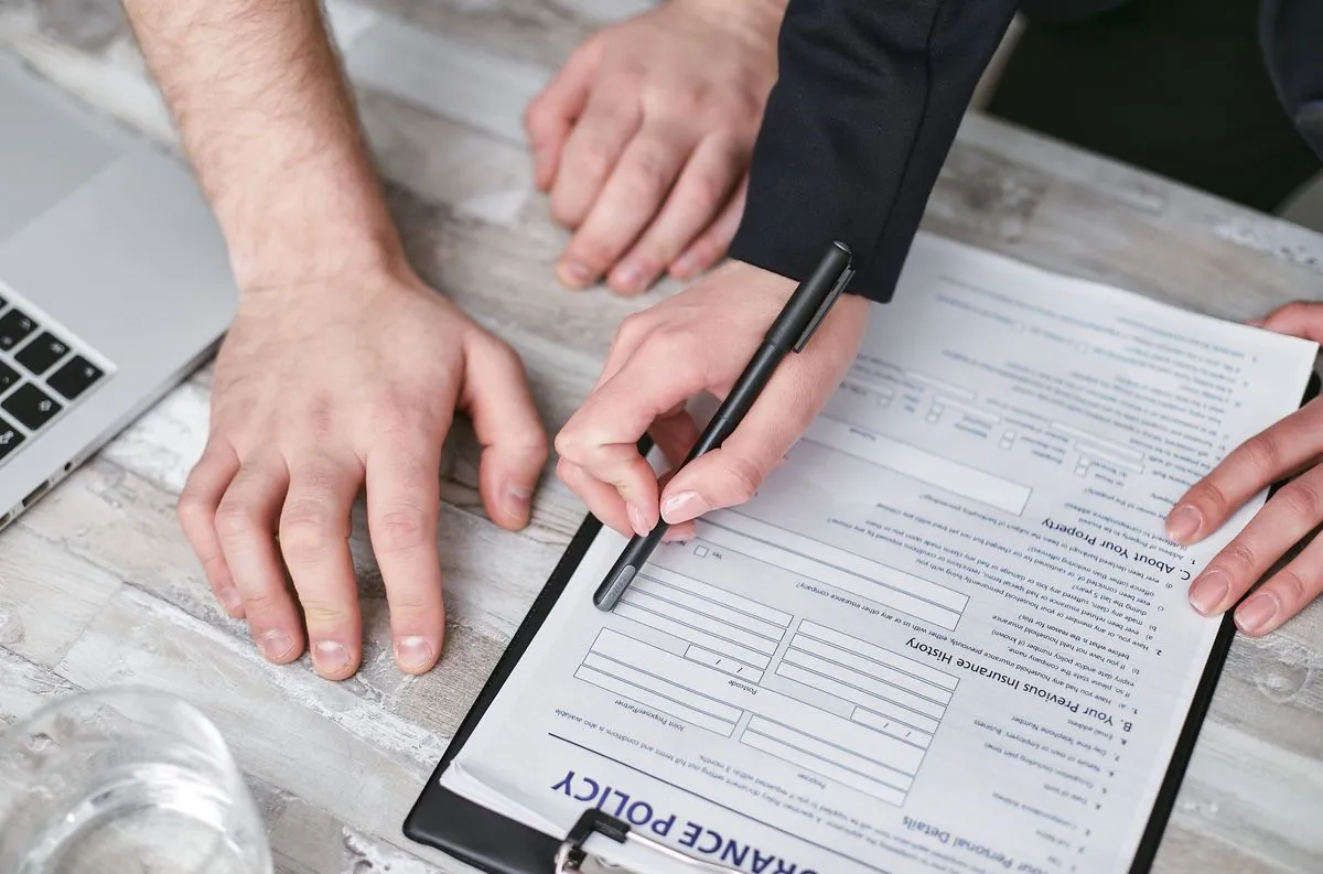 Two people signing a liability insurance document