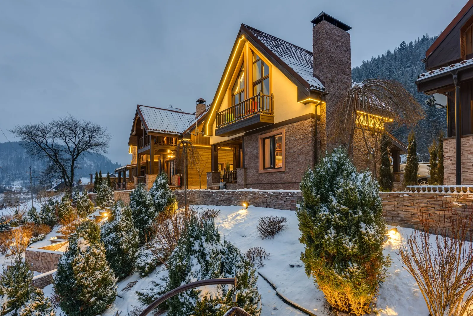 Chalet illuminato nella neve al tramonto, una tipica prenotazione per famiglie su VRBO