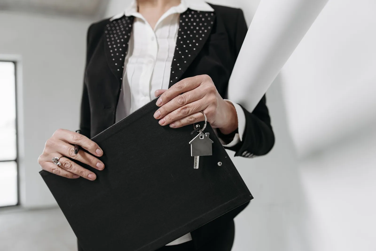 Vastgoedbeheerder met een klembord en een huisvormige sleutelhanger