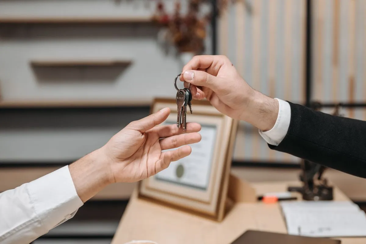 Hôte remettant un trousseau de clés à un voyageur, le moment d'arrivée qui décide de la note Arrivée sur Airbnb