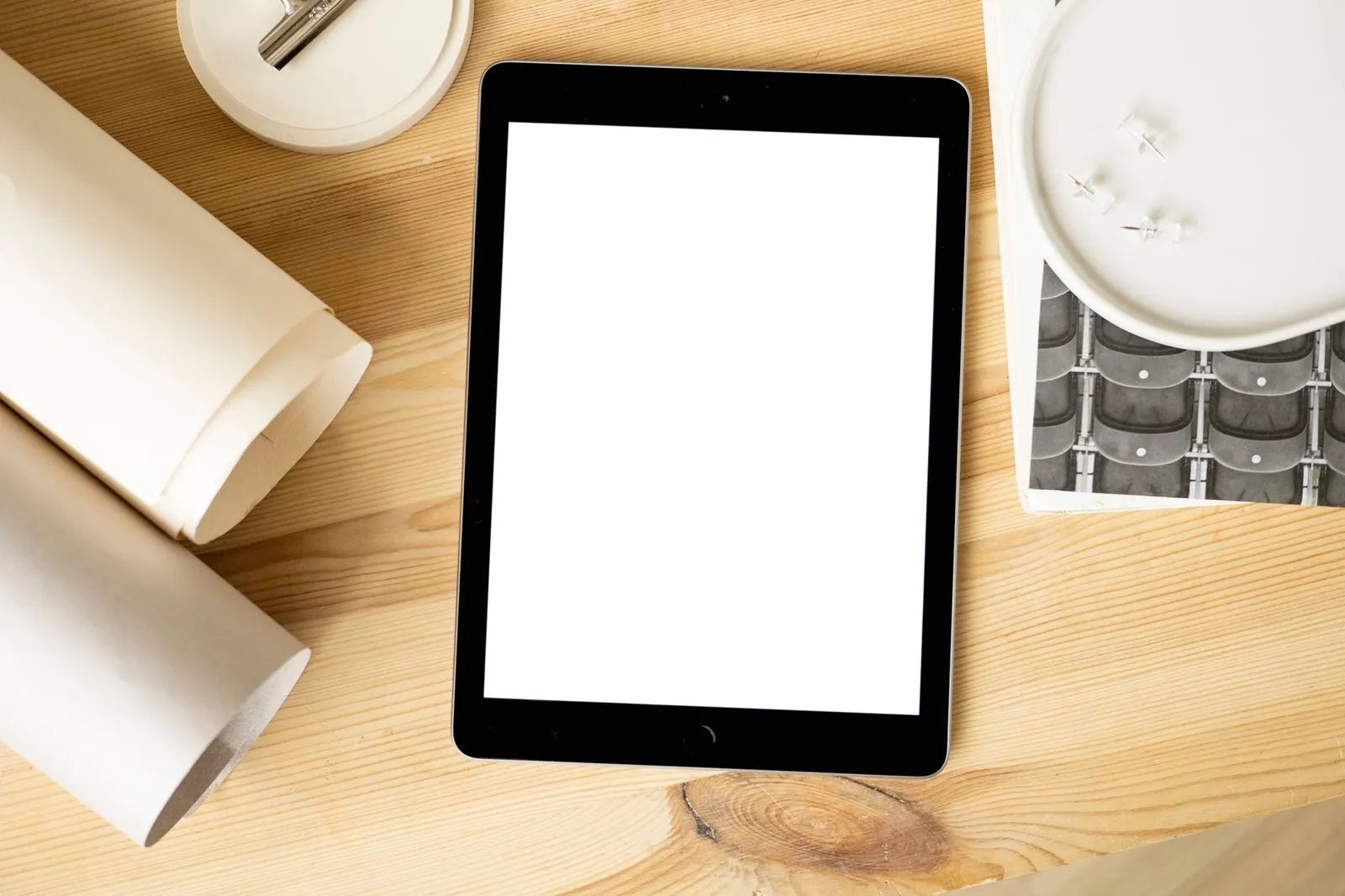 Tablette à l'écran vide sur un bureau en bois avec des fournitures