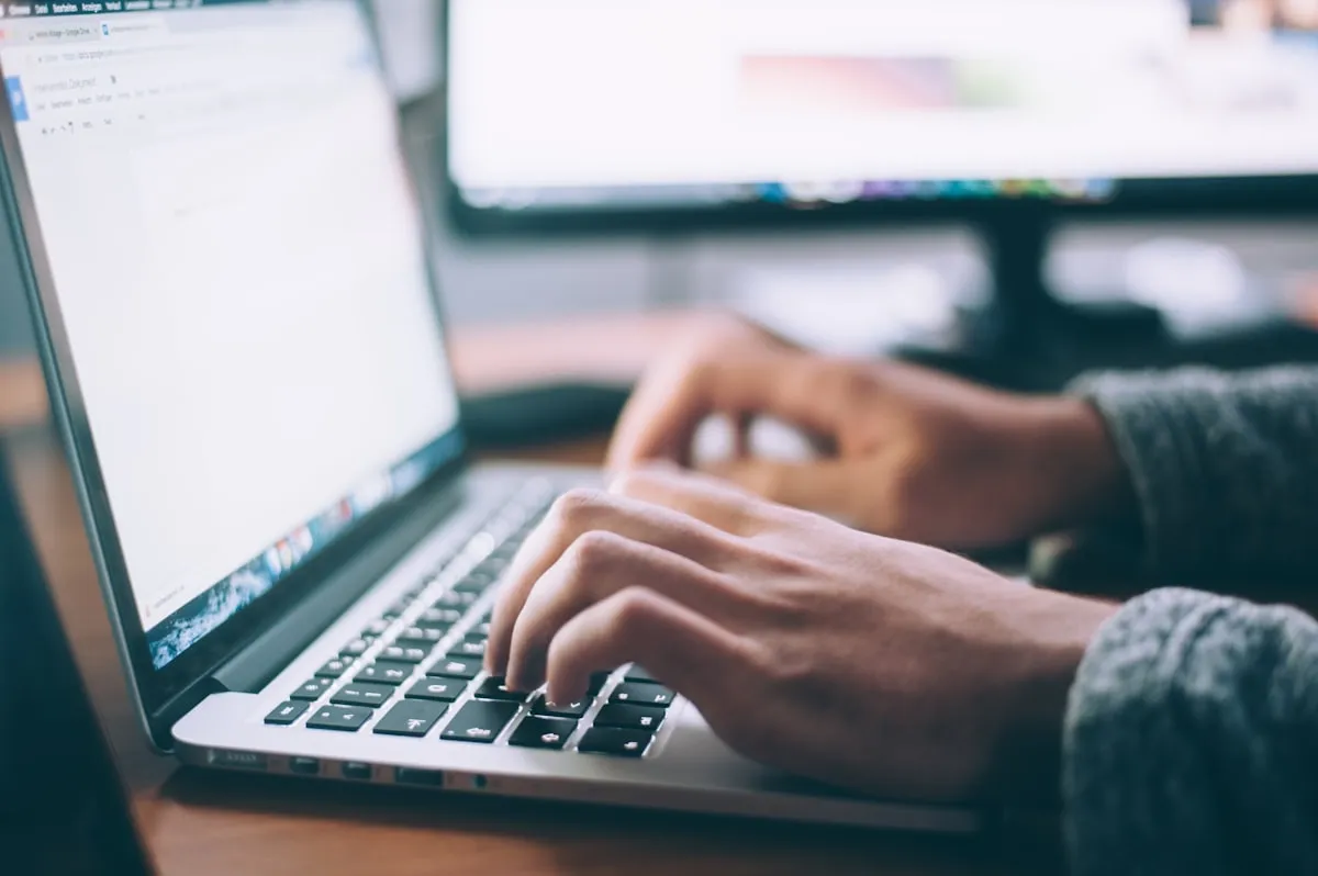 Property manager automating Booking.com guest messages on laptop to improve Reply Score